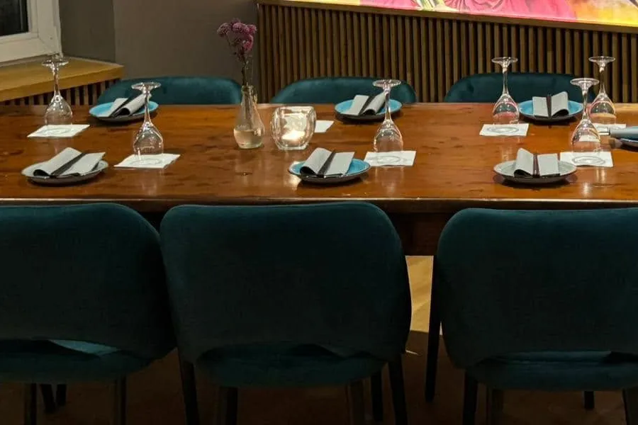 Weingläser, Kerze und gefaltete Servietten auf einem Holztisch
